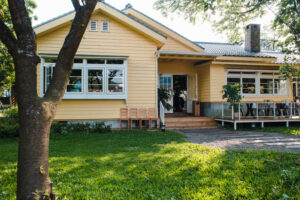 charming-yellow-house-with-wooden-windows-green-grassy-garden